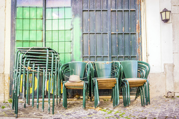 Stacked green tables and chairs on Lisbon street, Portugal
