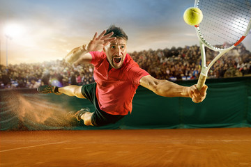 The one jumping player, caucasian fit man, playing tennis on the earthen court with spectators