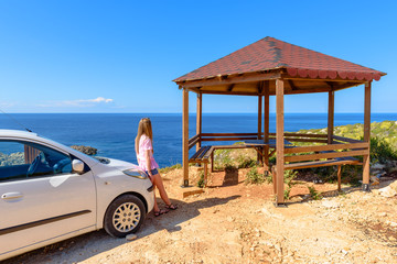 Young woman tourist standing on viewpoint place and looking at sea. Zakynthos island in Greece