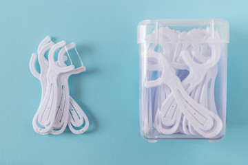 A box of white dental flossers on bright blue background.