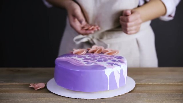 Step by step. Pastre shef decorating mousse cake with purple mirror glaze with chocolate pink flower