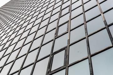 Glass surface of skyscrapers view in district of business centers with reflection on it, black and white