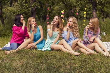 Cute sexy gorgeous caucasian woman in sensual dresses on a girls party before wedding posing happily outdoors in a park in summer daylight