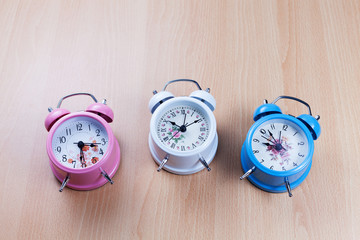 beautiful new classic alarm clock on wooden background.