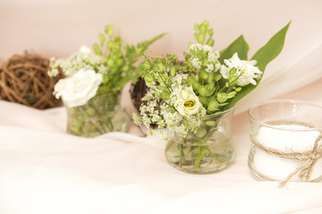 Simple but luxury rich table setting for a wedding celebration in nice cozy restaurant. Wineglasses, plates and bouquet of summer seasonal flowers on a table. Sunlight from a window. Copy space