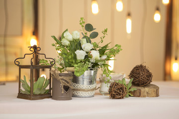 Simple but luxury rich table setting for a wedding celebration in nice cozy restaurant. Wineglasses, plates and bouquet of summer seasonal flowers on a table. Sunlight from a window. Copy space