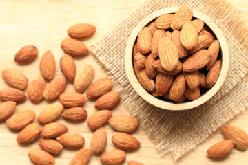 Almond in a bowl on wooden background