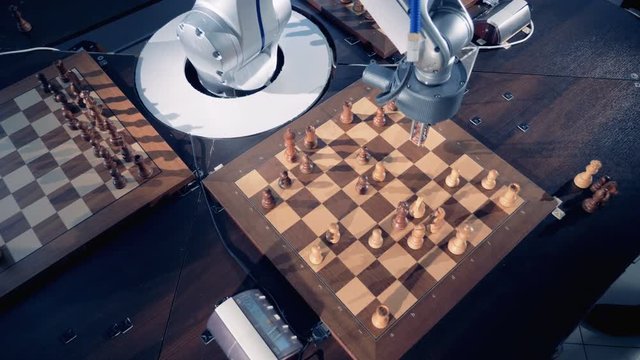 Human and robotic arms are moving chess pieces while playing