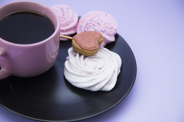 Coffee with sweets on light purple background