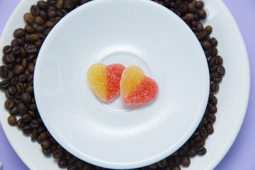 Coffee with sweets on light purple background