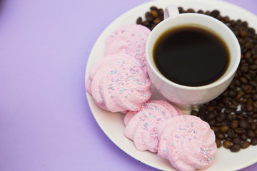 Coffee with sweets on light purple background