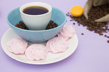 Coffee with sweets on light purple background