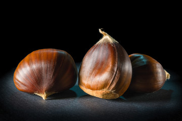 Still life of some chestnuts on a black background.