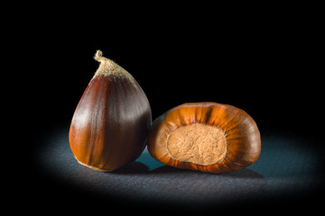 Still life of some chestnuts on a black background.