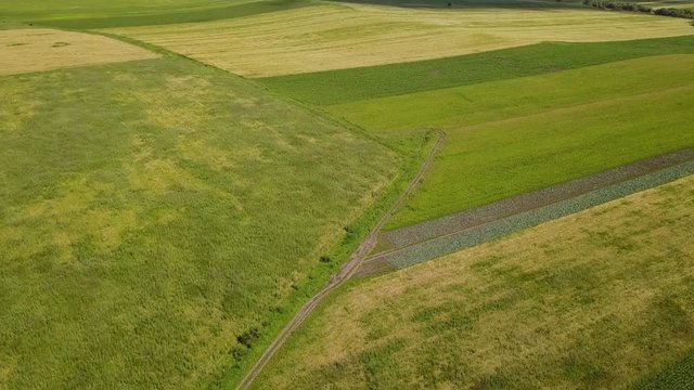 Road among green fields in Cherkessk, Karachaevo-Cherkessia. Beautiful view from above, shooting from a quadopter, 4K