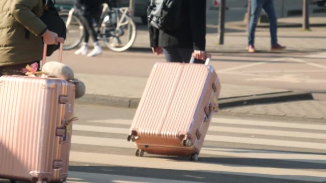 Trolley bag being dragged on street by tourist in Amsterdam.