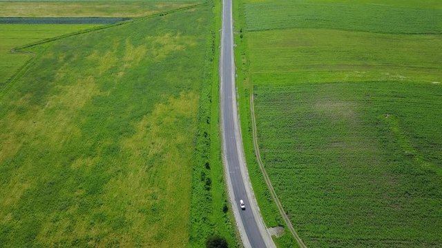 Road among green fields in Cherkessk, Karachaevo-Cherkessia. Beautiful view from above, shooting from a quadopter, 4K