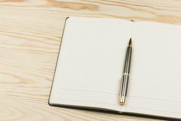 Notepad with pen  on wooden background