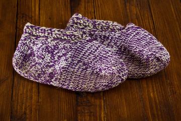 Handmade knitted wool socks on wooden background