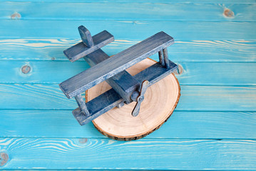Деревянный синий самолет на срезе дерева на голубом деревянном фоне вид сверху © jloginova
