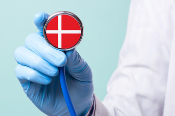 Medicine in Denmark is free and paid. Expensive medical insurance. Treatment of disease at the highest level Doctor holding a stethoscope in his hand