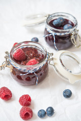 breakfast with blueberry and raspberry jam on a white paper background