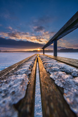 Sun setting down behind frozen lake in winter