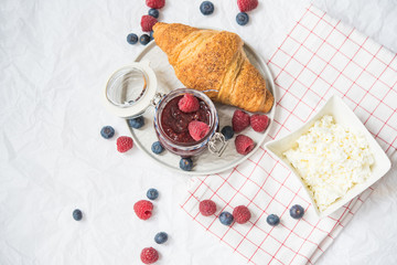  reakfast with raspberry and blueberry jam, croissants and cottage cheese