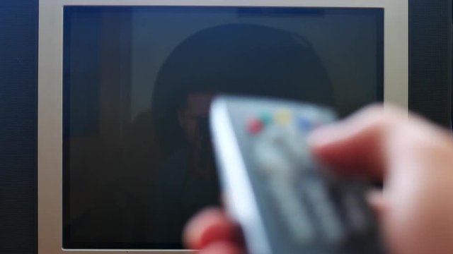 Close up shot of a male hand holding the TV remote control and changing television channels with no signal noise and go crazy and nervous