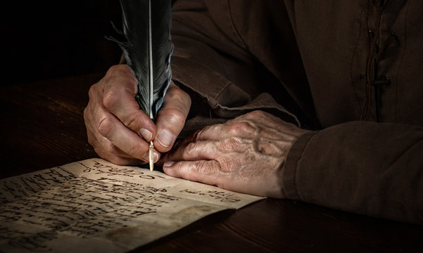 Hände schreiben einen Brief im Mittelalter