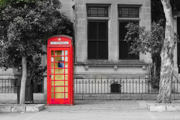An iconic red telephone box in maltese town Mdina. Malta English language school education concept. Black, white and color mixed toned gift card, copy space. © prystai