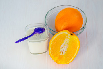 Yogurt in a glass cup and orange juice on a white background