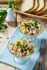 Easter recipe, festive snack. Salad with salmon, pickled cucumber, potatoes and capers - on the festive table.