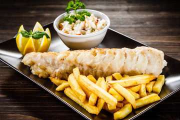 Fish dish - fried fish fillet with french fries and vegetables 
