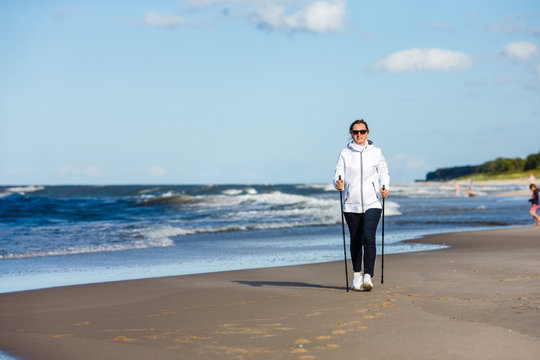 Nordic walking - woman training on beach 