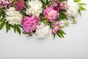 Fresh white and pink peonies flowers on white background. Top view, flat lay. Place for text.