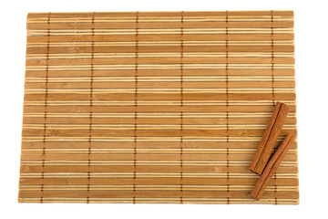 cinnamon sticks on bamboo mat isolated on white background