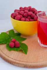 Home juicy raspberries poured in a bowl on a wooden table