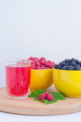 Home juicy raspberries poured in a bowl on a wooden table