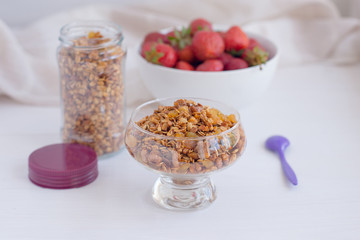 Homemade granola in jar on rustic kitchen table, healthy breakfa