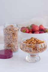 Homemade granola in jar on rustic kitchen table, healthy breakfa