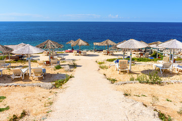 Sunbeds and parasol on Porto Roxa beach. Zakynthos island, Greece
