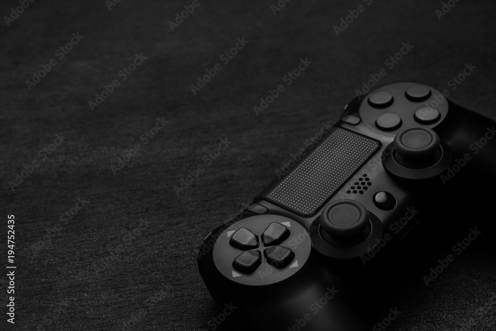 Wall mural black gamepad on a dark wooden background