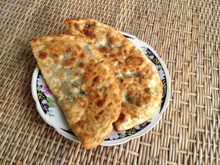 two hot breakfast  cutabs on a round plate on rattan background 