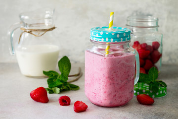 Mason jar mugs with fresh berry cocktails and ingredients for cooking smoothies against a background of gray stone or slate. The concept of proper nutrition and health or detoxification. Copy space.