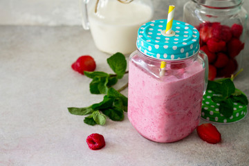 Mason jar mugs with fresh berry cocktails and ingredients for cooking smoothies against a background of gray stone or slate. The concept of proper nutrition and health or detoxification. Copy space.