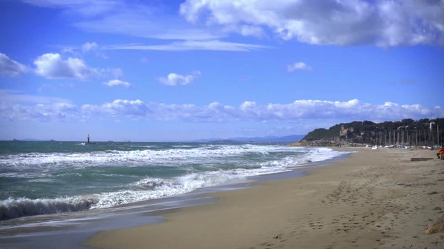 Slow motion 120fps shoot of sea waves breaking on a sandy beach. Mediterranena sea waves in Altafulla, Spain.