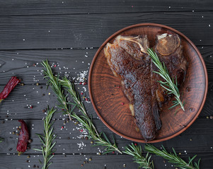 T-Bone Steak with Fresh Herbs on a rustic wooden table
