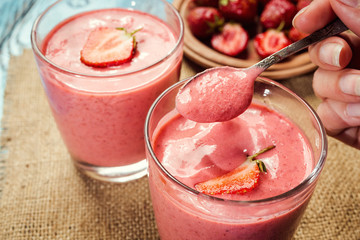 healthy strawberry yogurt with fresh berries on old wooden background