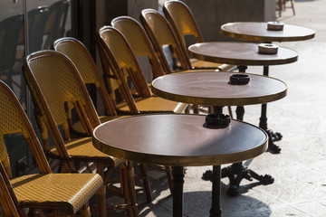 Row of cafe chairs and tables outside on terrace